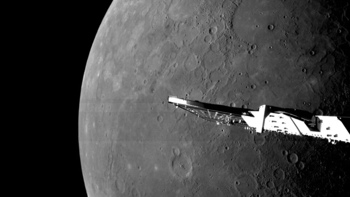 A black and white image of a spacecraft wing in front of a large planet with some craters.