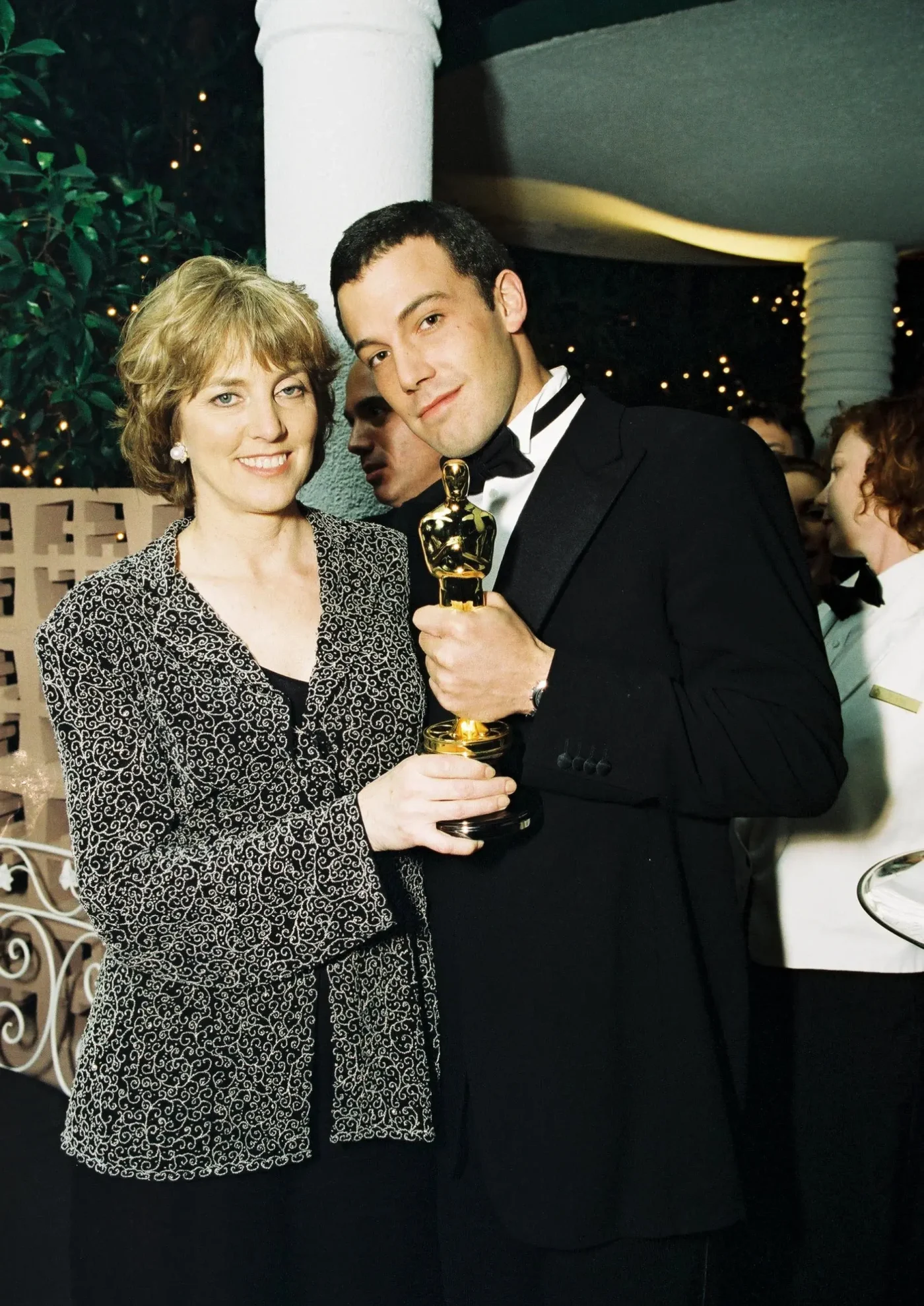 Ben Affleck and his mother Chris holding an Oscar statue.