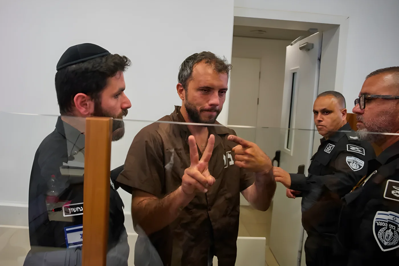 Brazilian activist Thiago Ávila, center, a member of the Global Sumud Flotilla, is escorted by prison service guards to a hearing at the District Court in Ashkelon, Israel, on Sunday, May 3, 2026. (AP Photo/Ohad Zwigenberg)