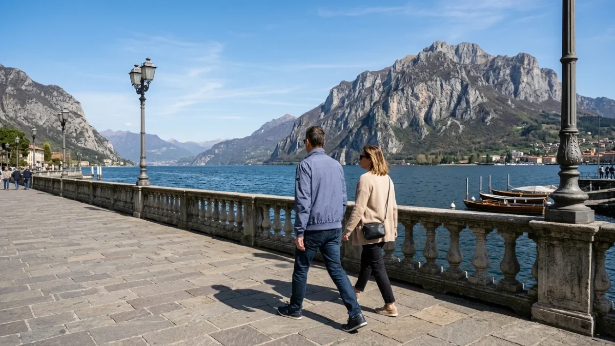 Veduta panoramica del ramo del lago di Lecco circondato dalle montagne prealpine illuminate dal sole
