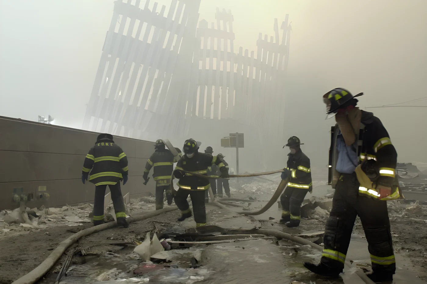 In this September 11, 2001, photo, firefighters work beneath destroyed mullions, the vertical struts which once faced the outer walls of the World Trade Center towers, after a terrorist attack on the twin towers in New York.