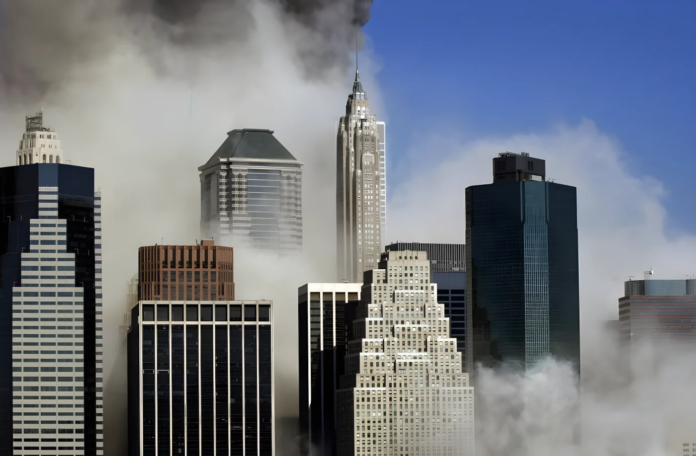 Smoke blows between buildings in Manhattan as seen from Brooklyn after the collapse of New York
