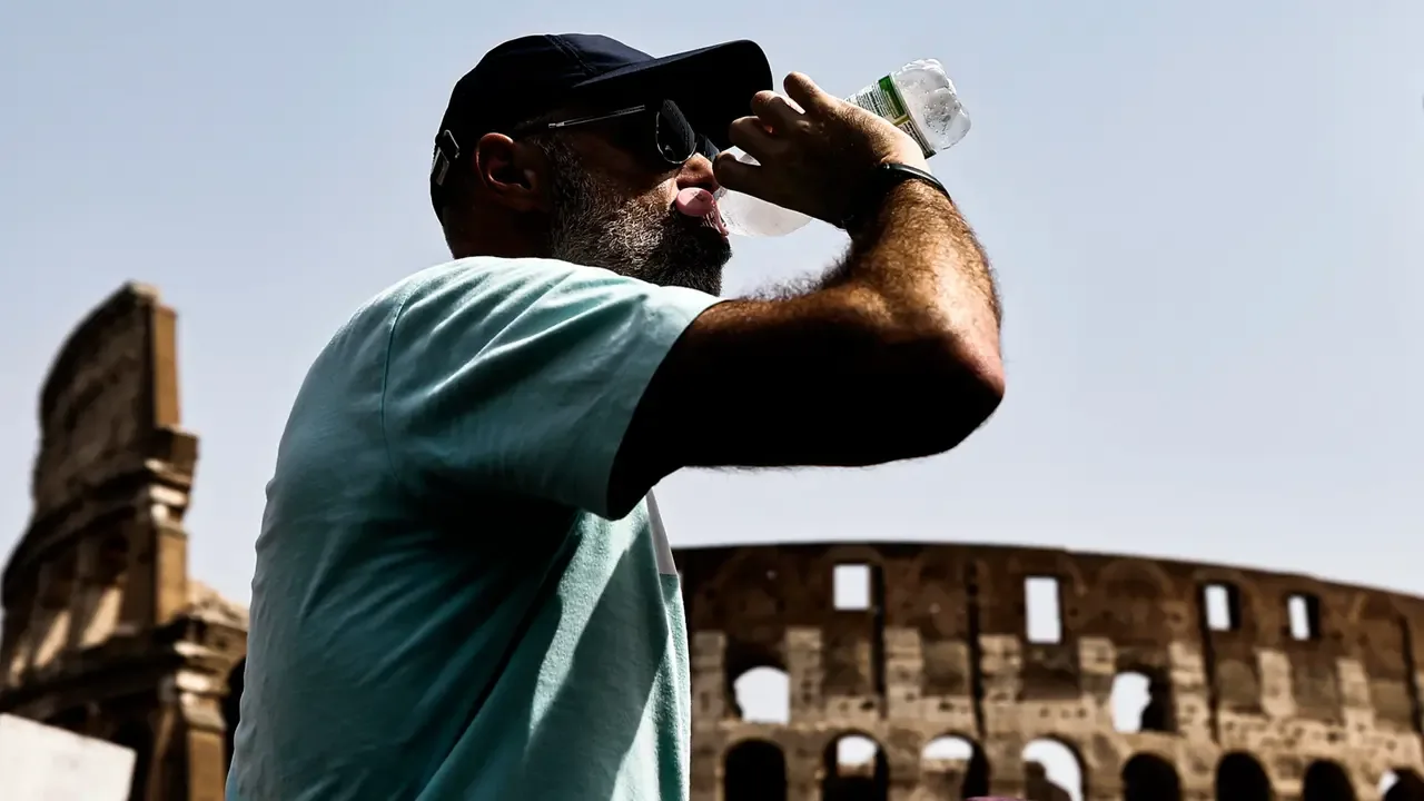 Un turista davanti al Colosseo cerca refrigerio durante l’ondata di caldo (Ansa)