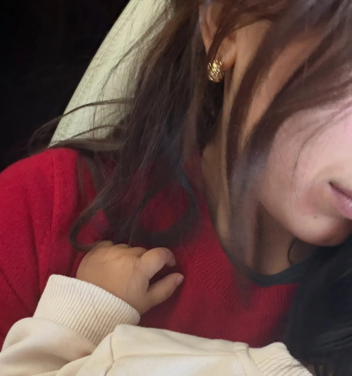 A close-up photo of Millie Bobby Brown holding a baby. Brown