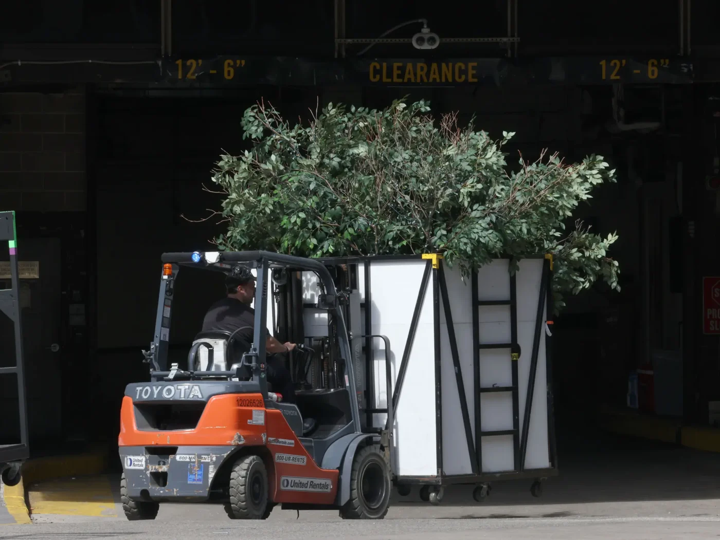 A forklift moves wedding equipment and greenery out of Madison Square Garden.
