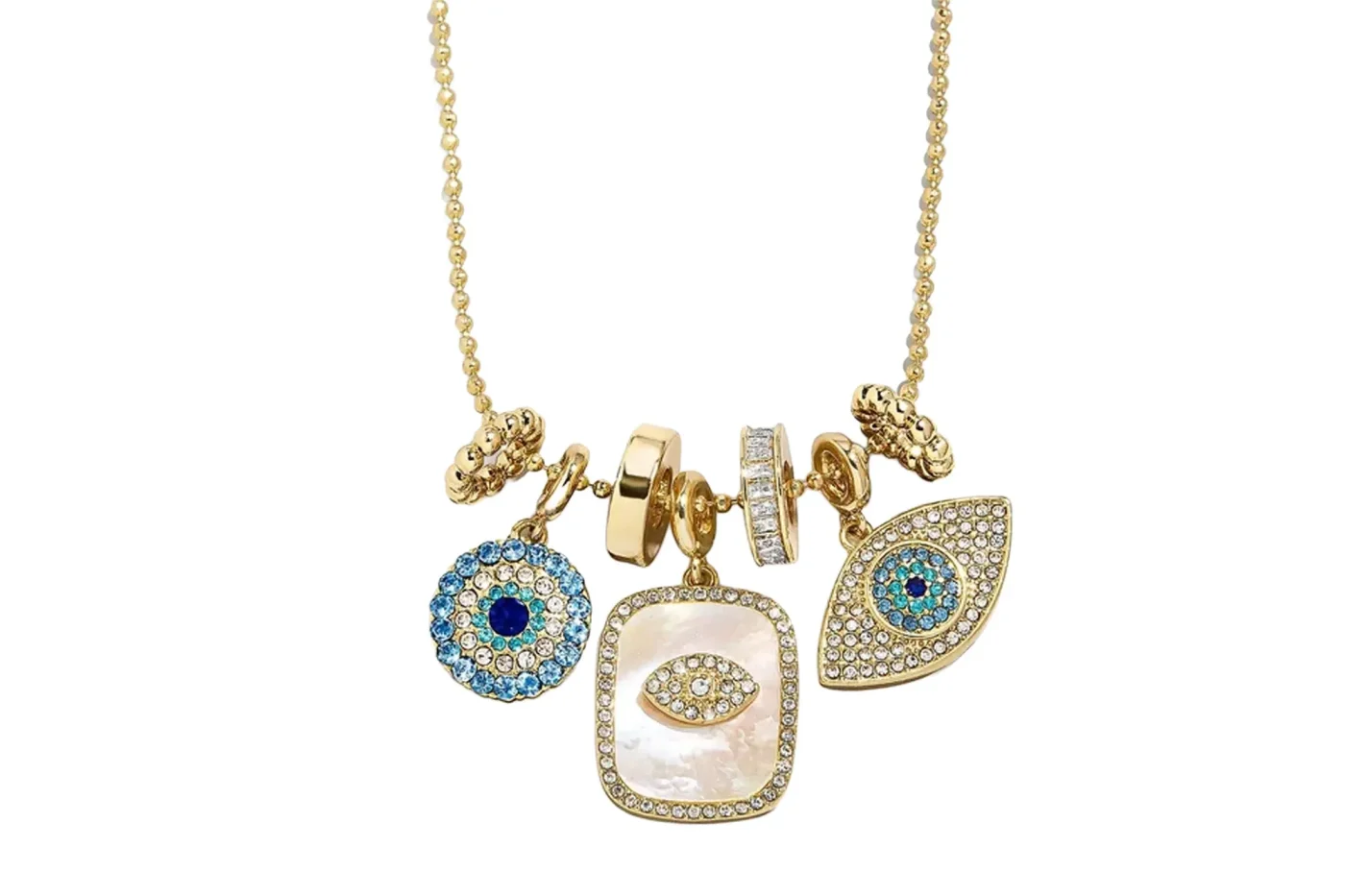 A gold necklace featuring multiple charms, including a round blue crystal-encrusted evil eye, a rectangular mother-of-pearl pendant with a rhinestone eye motif, and an eye-shaped pendant decorated with blue and clear crystals.