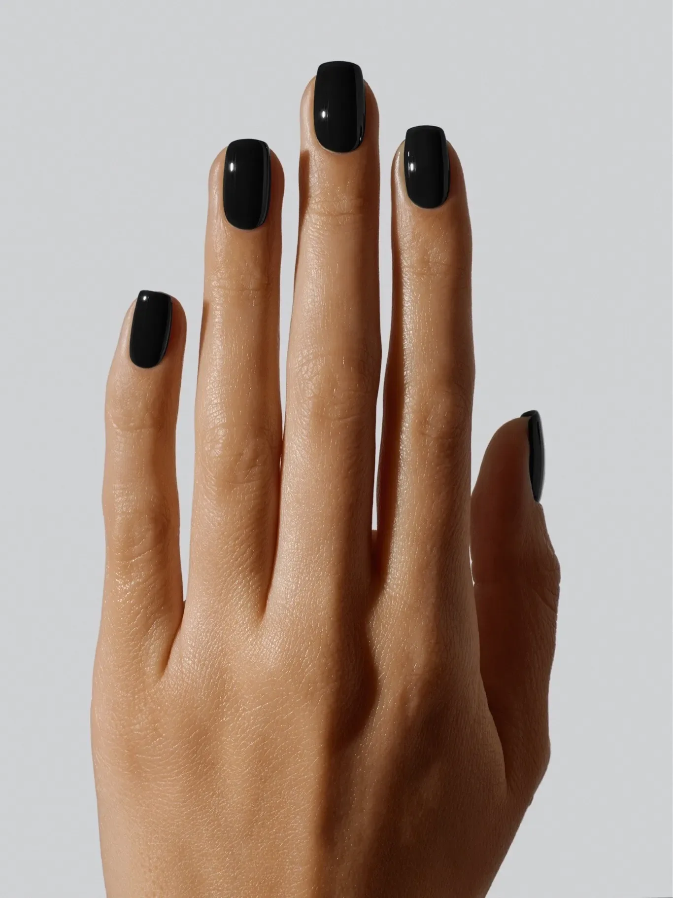 A hand with a manicure featuring glossy nails