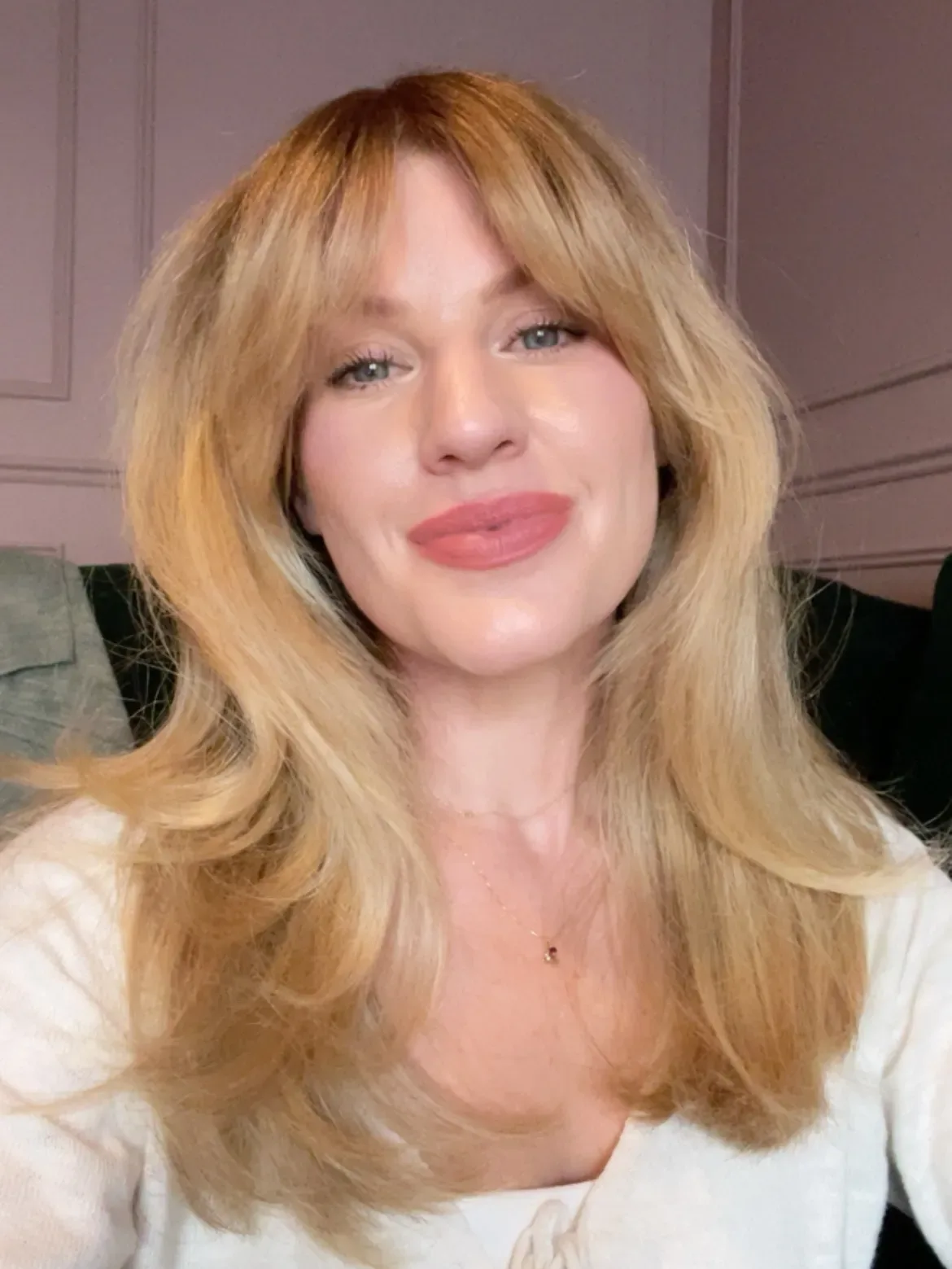 A person with mediumlength hair smiling at the camera