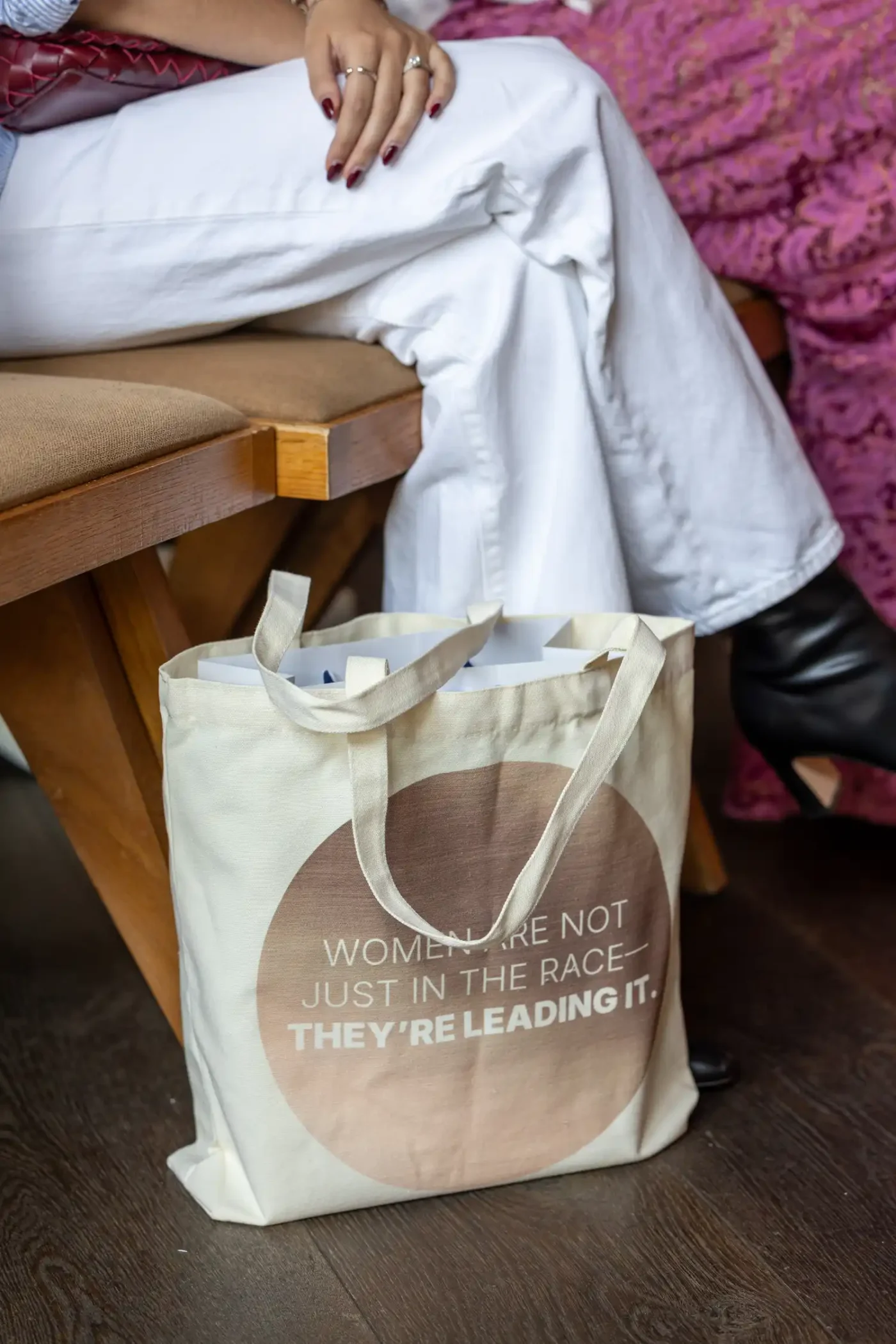 A tote bag that reads "Women are not just in the race—they