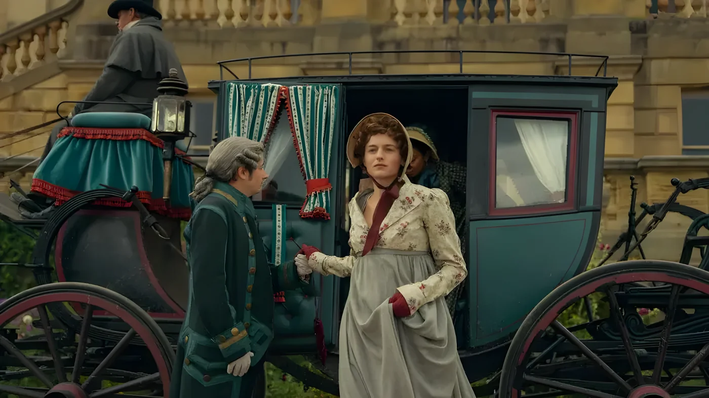A woman in a floral top and gray skirt stands by a carriage, talking to a man in green attire.