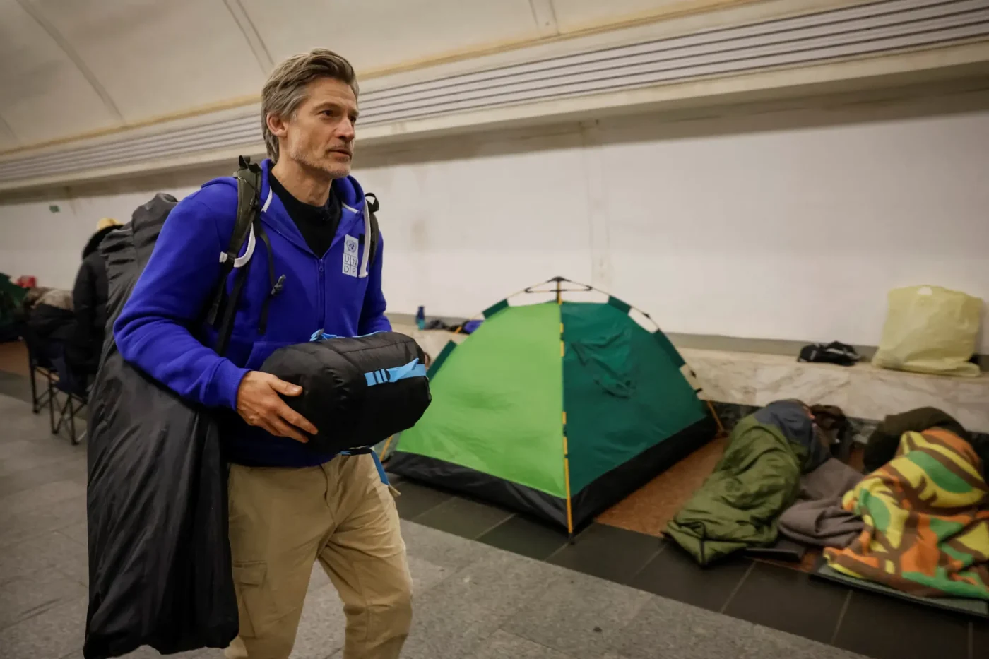 Actor Nikolaj Coster-Waldau carries luggage inside a metro station acting as a bomb shelter in Kyiv, Ukraine.