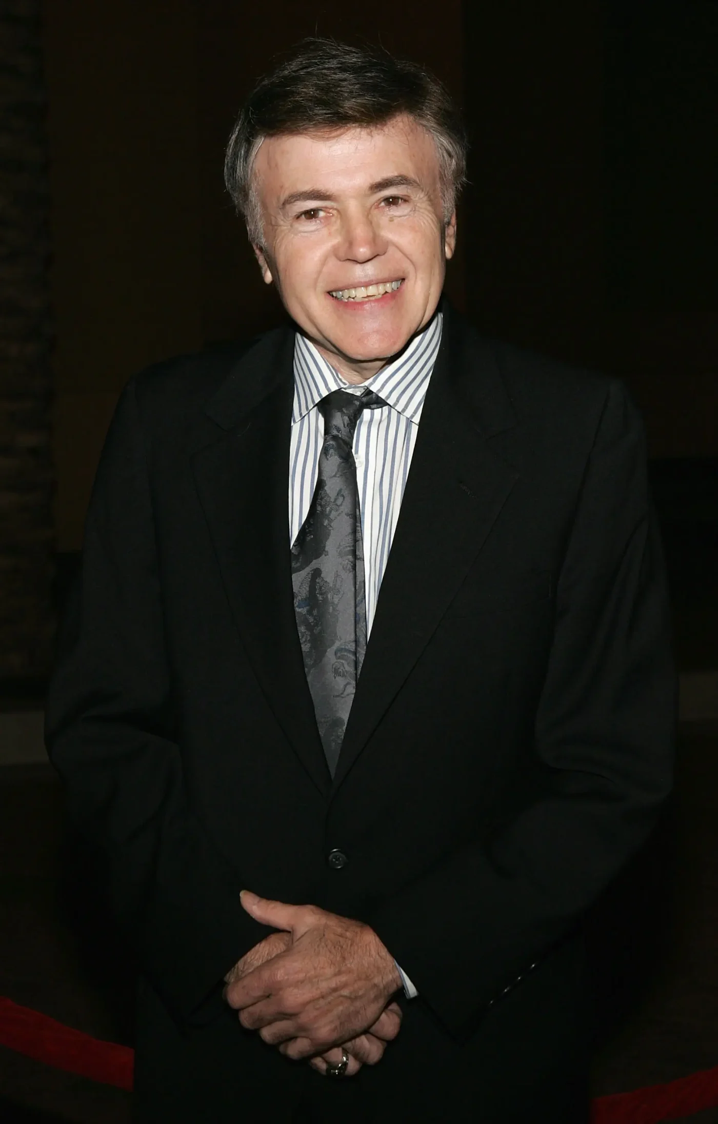 Actor Walter Koenig smiling in a suit and tie.