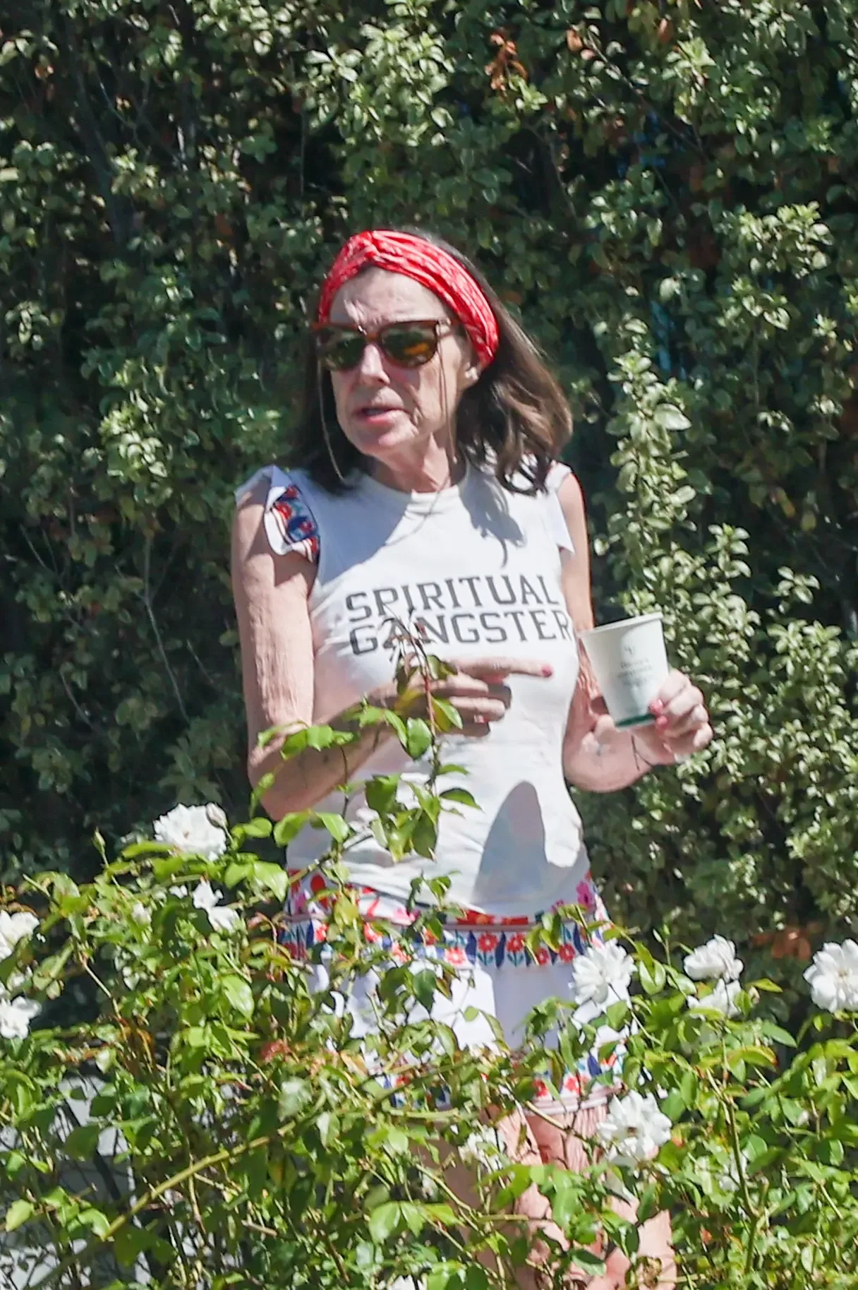 Actress Susan St James wears a red headband and a