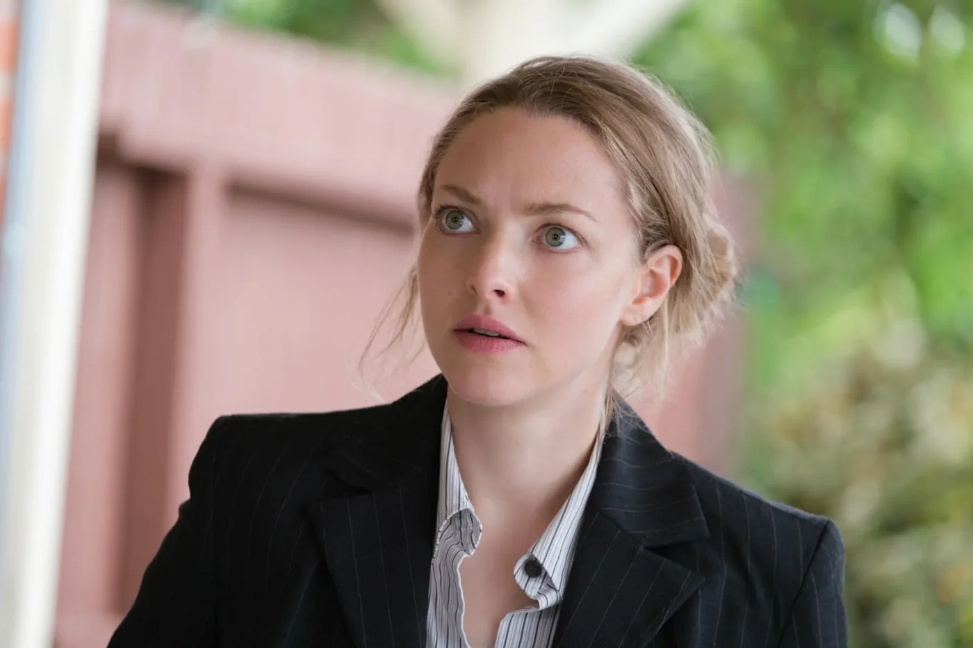 Amanda Seyfried as Elizabeth Holmes in a pinstriped suit.