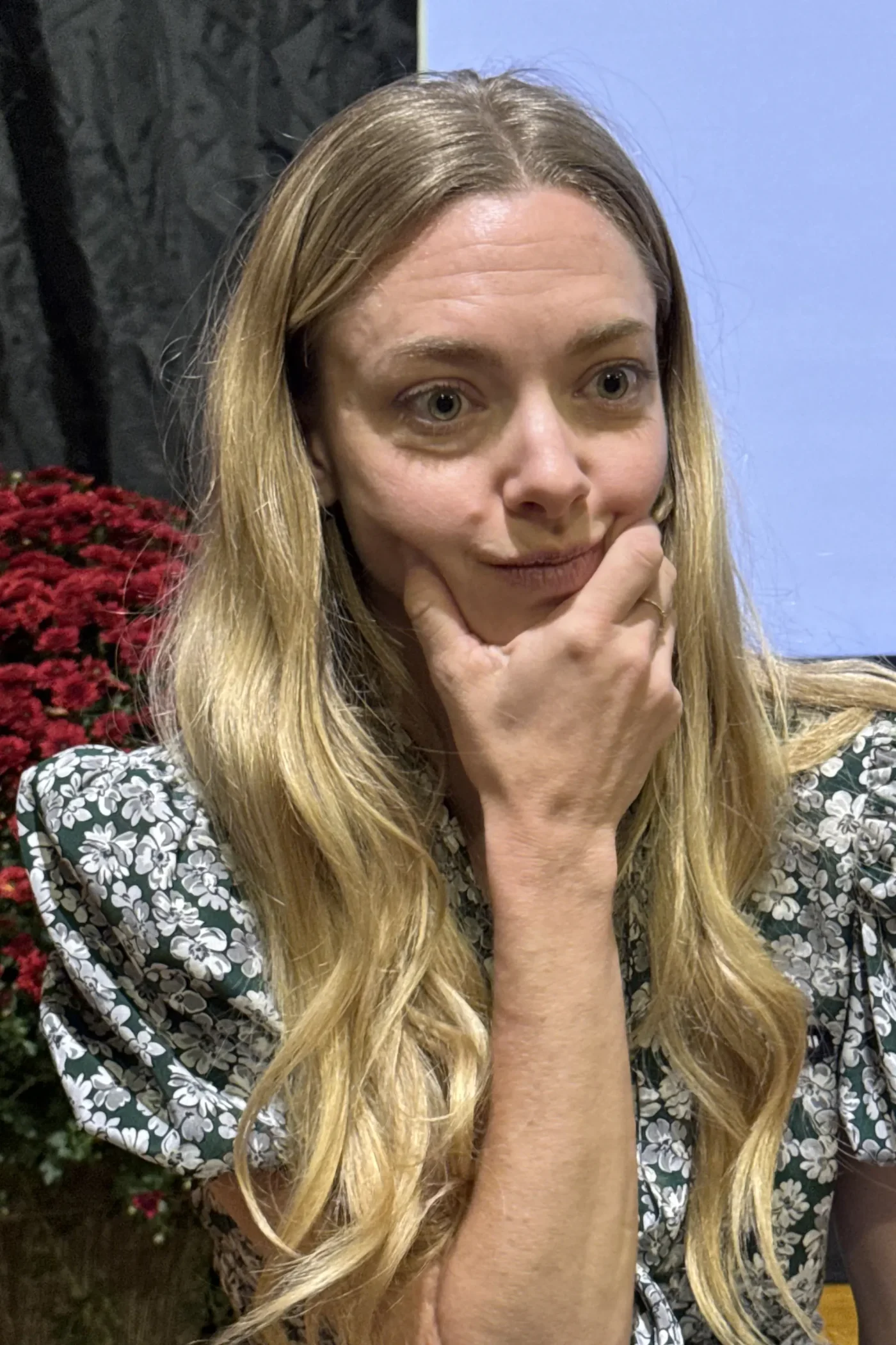 Amanda Seyfried resting her chin on her hand during an event.