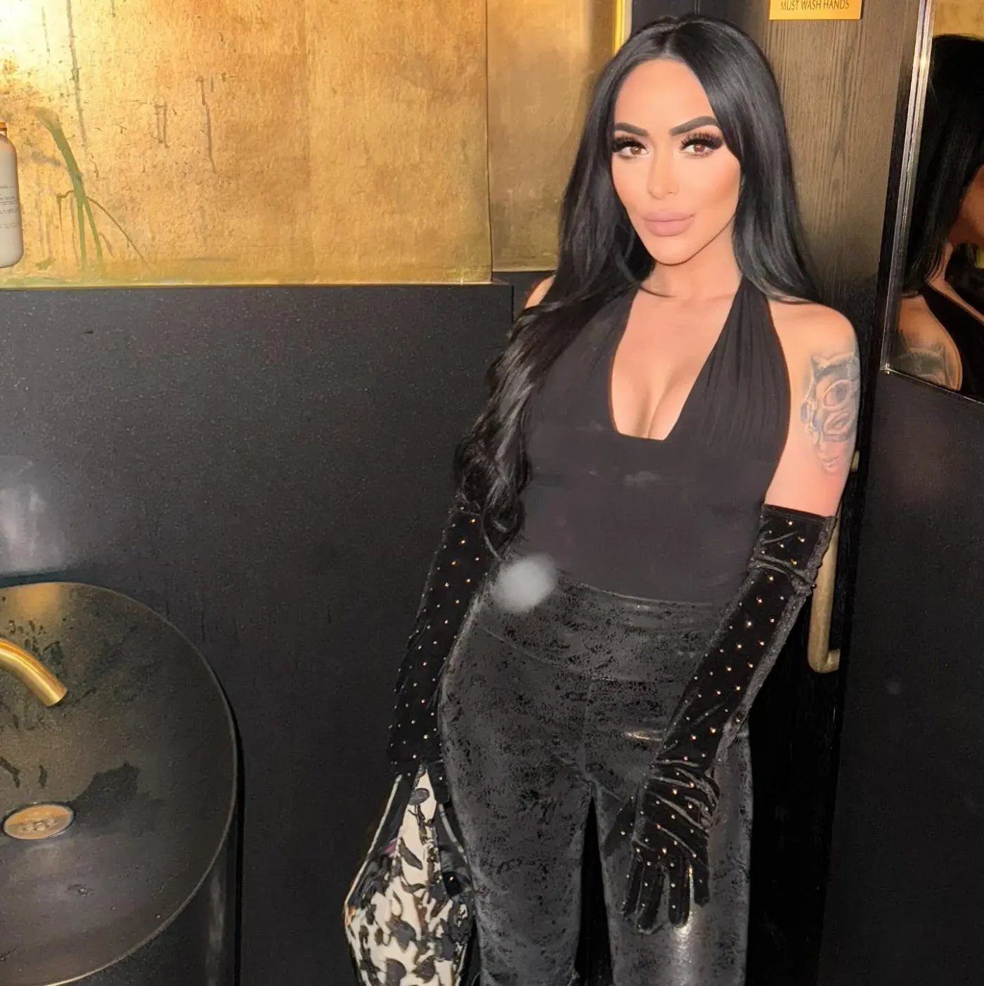 Angelina Pivarnick wearing a black halter top, matching pants, and long gloves.