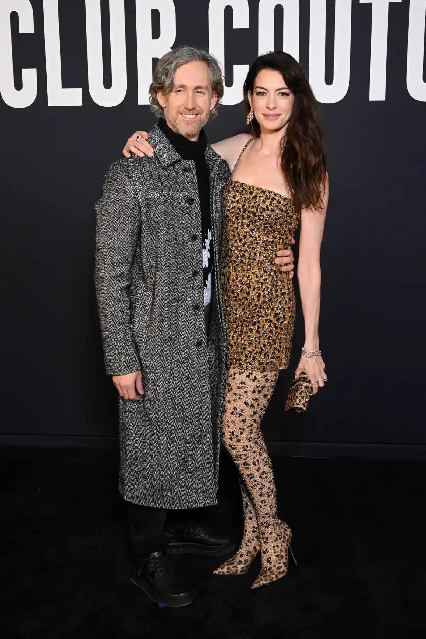 Anne Hathaway posing with a companion at a fashion event