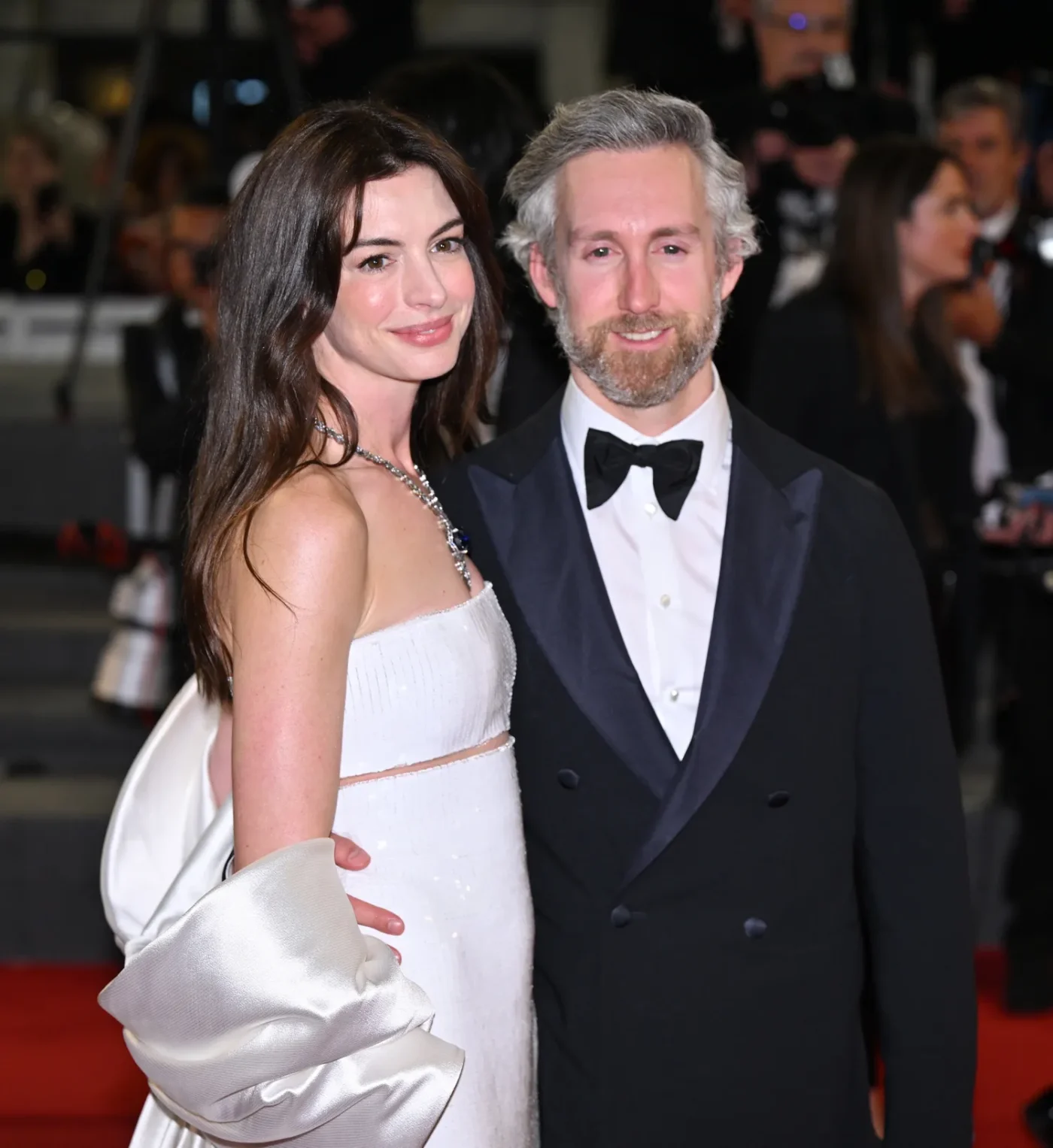 Anne Hathaway posing with a man at a formal red carpet event