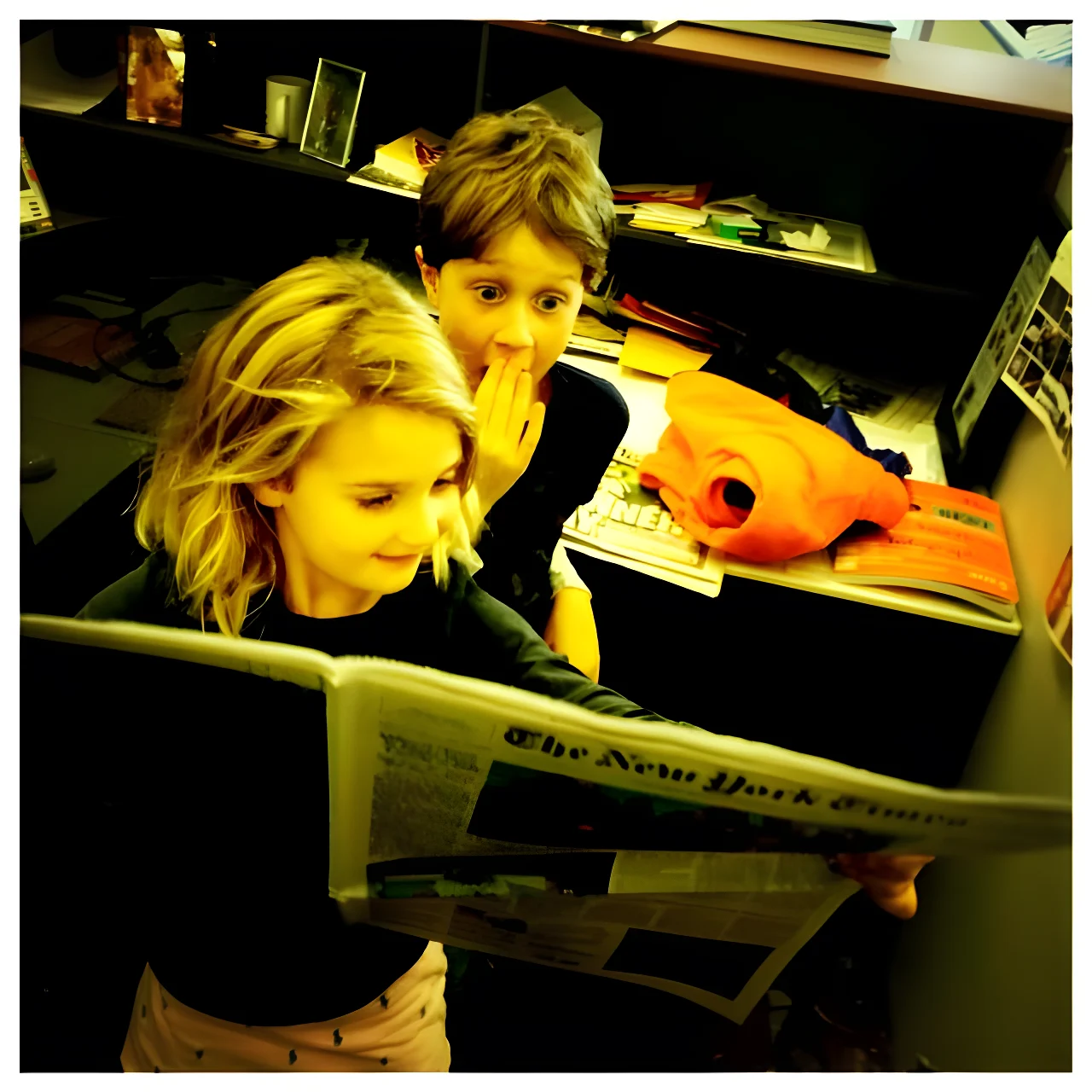 Ariel Ehrlich and his sister Eleanor reading a newspaper, with Ariel looking shocked and covering his mouth.