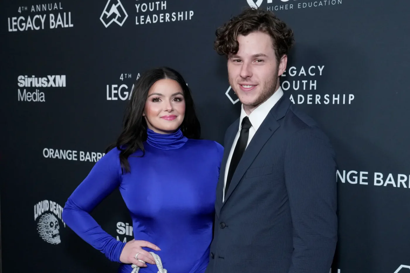 Ariel Winter and Nolan Gould pose together in front of a branded step-and-repeat backdrop at the 4th Annual Legacy Ball.