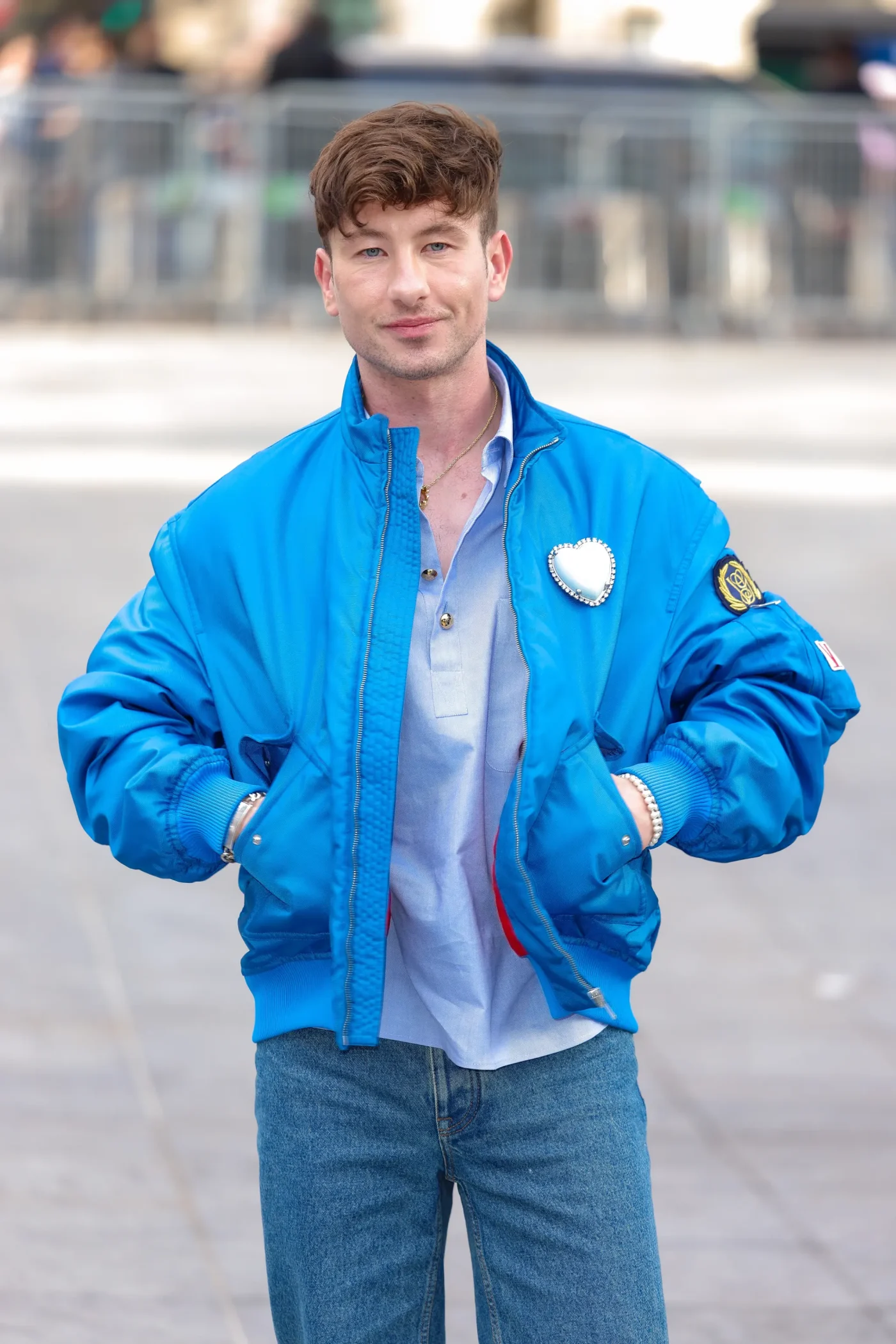 Barry Keoghan wearing a bright blue bomber jacket and jeans during Paris Fashion Week.