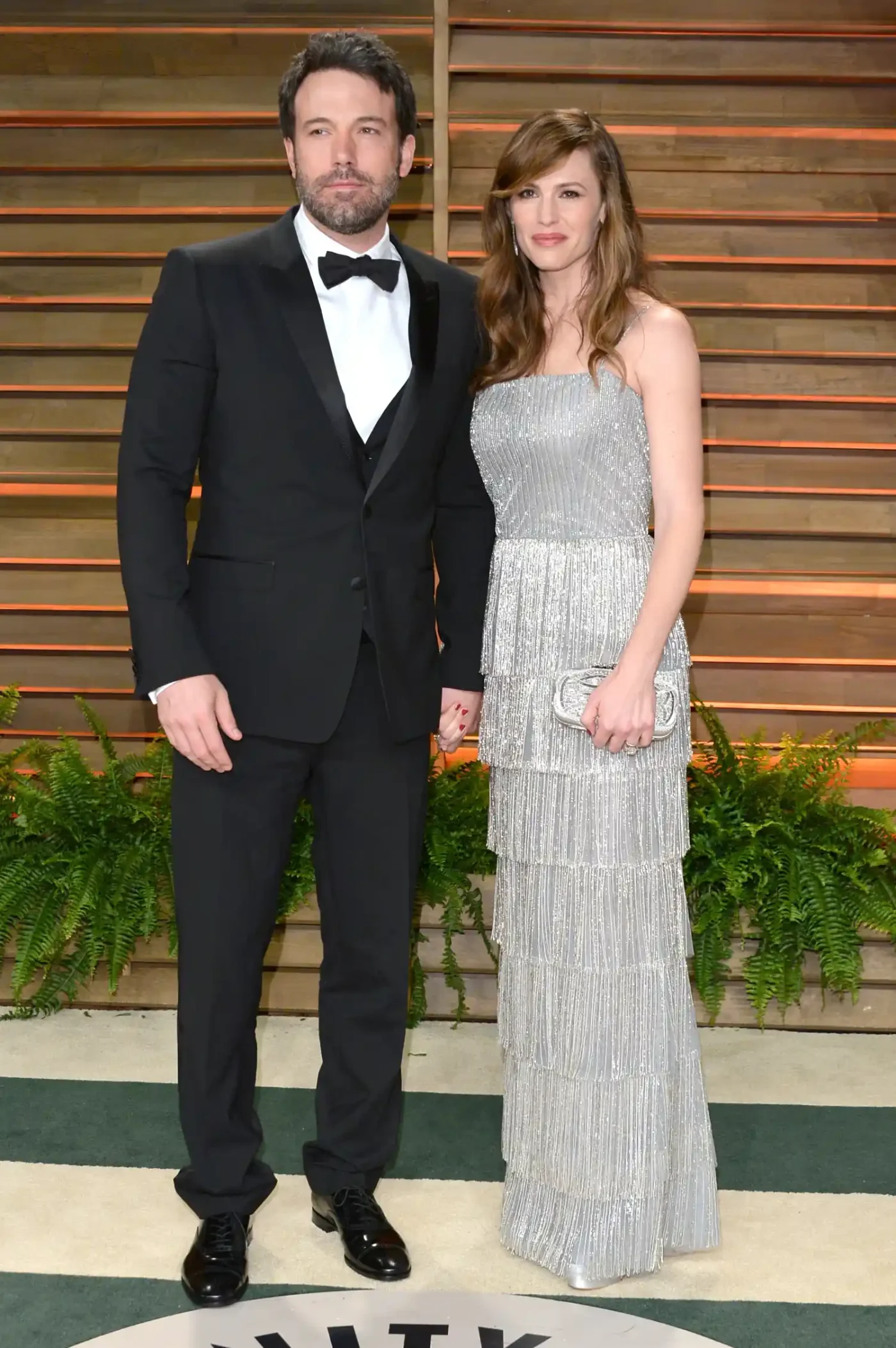 Ben Affleck posing formally with a woman on a red carpet event