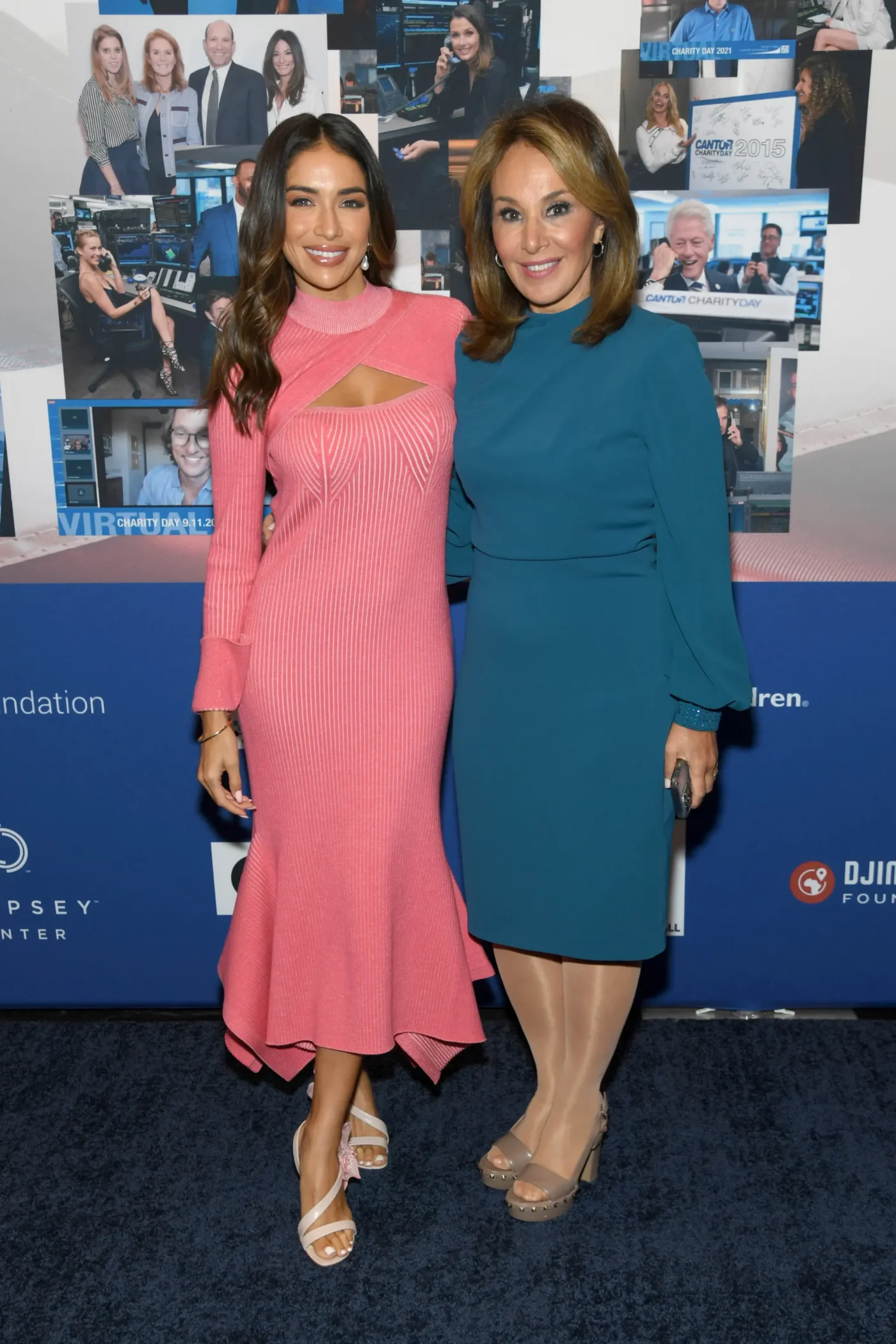 Bianca Peters and Rosanna Scotto pose together at a charity event in front of a photo backdrop.