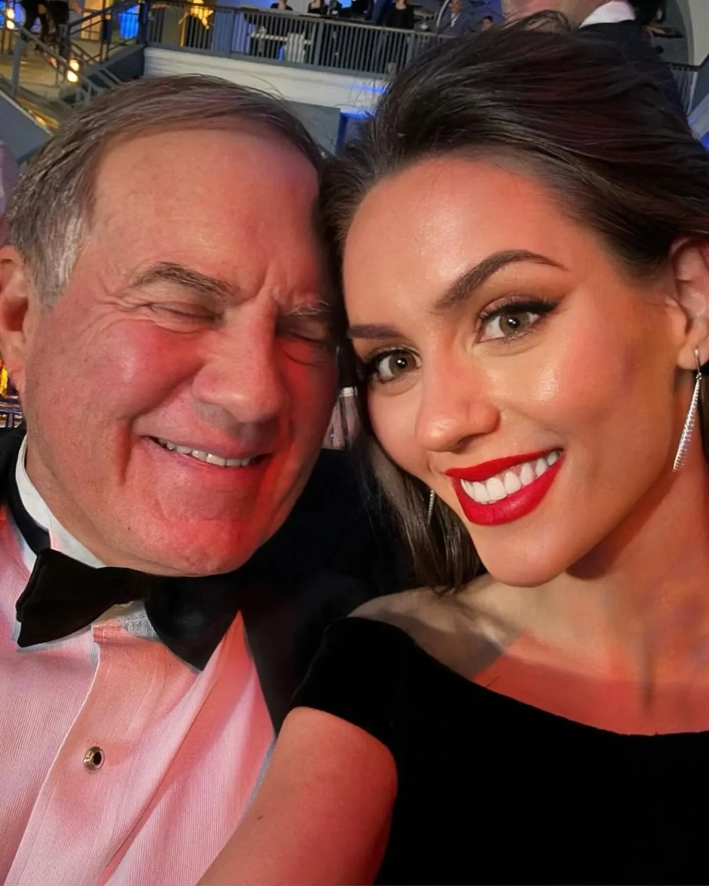 Bill Belichick and Jordon Hudson posing for a selfie on the red carpet.