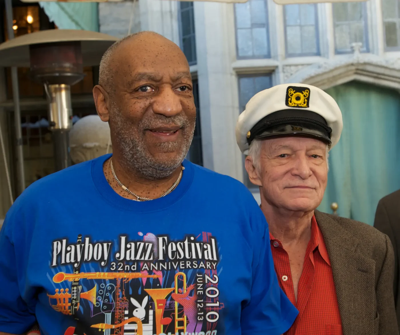 Bill Cosby and Hugh Hefner standing together at The Playboy Mansion.