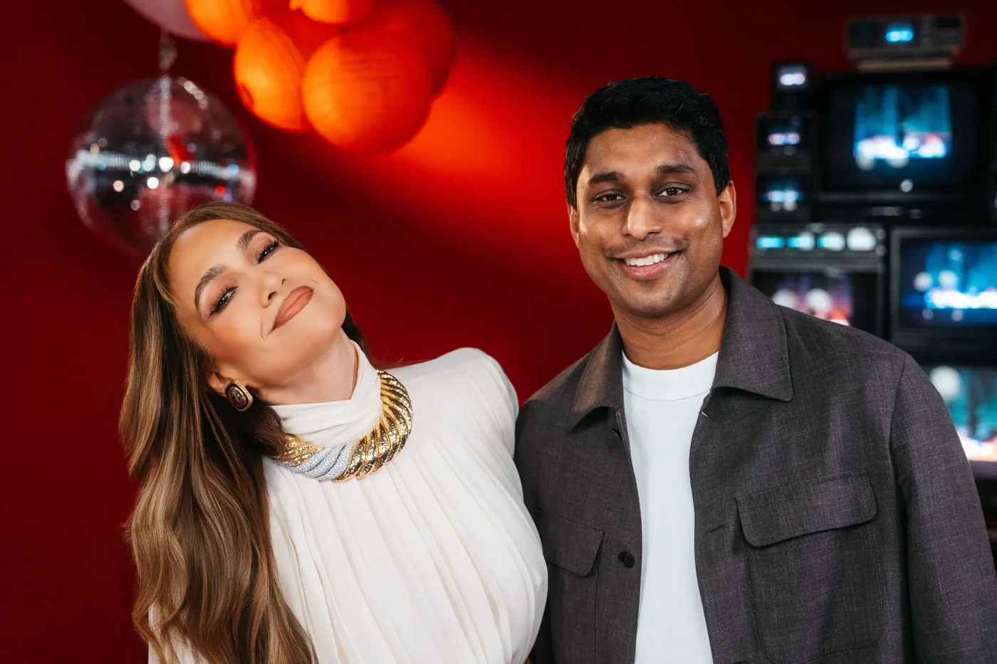 Bilt Founder and CEO Ankur Jain and Jennifer Lopez pose together in front of a red backdrop.