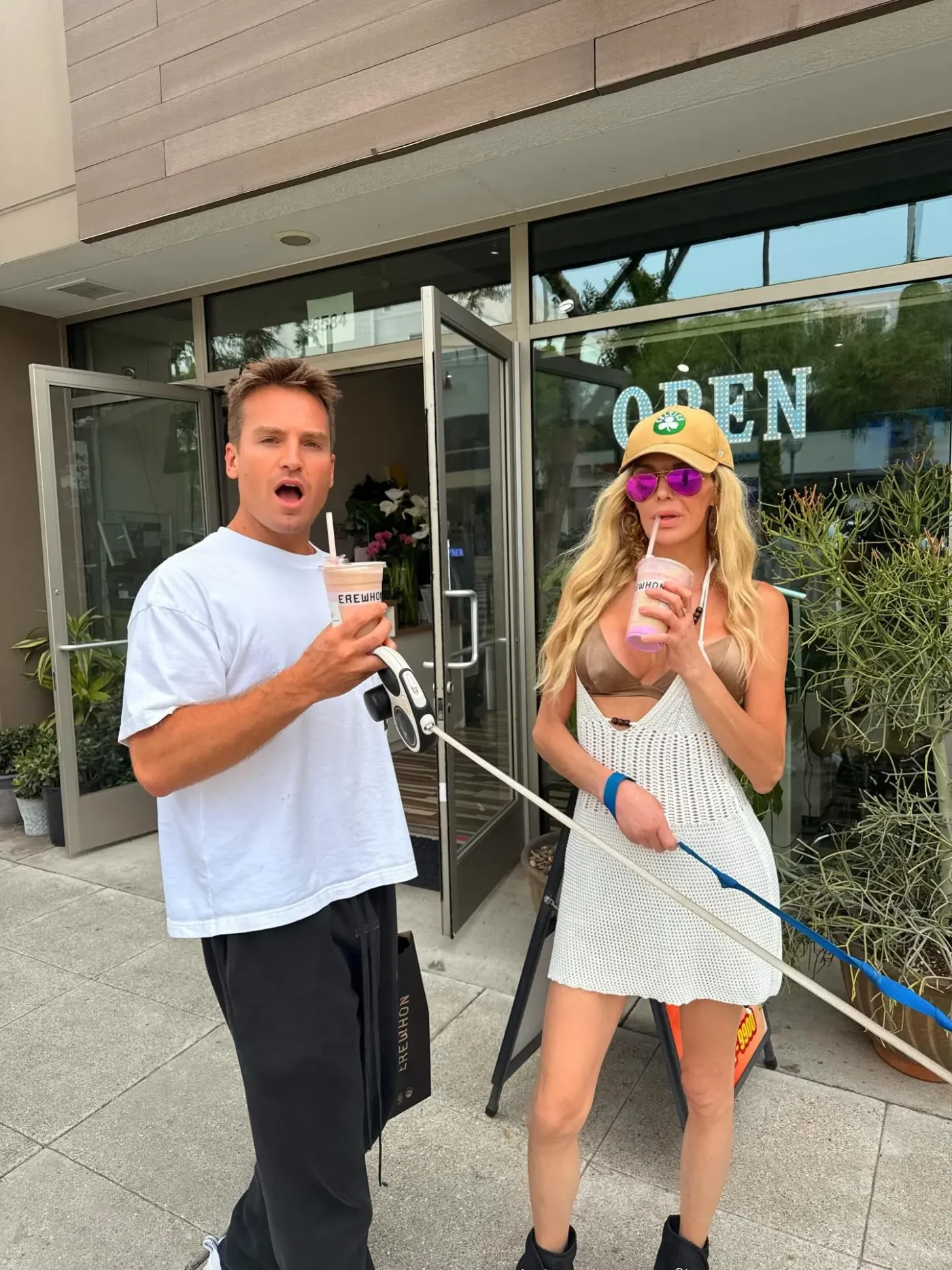 Brandi Glanville and podcast co-host James Maas outside a storefront.
