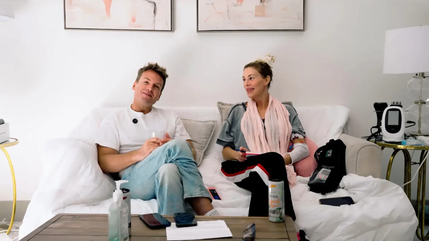 Brandi Glanville and podcast co-host James Maas sitting together on a couch.