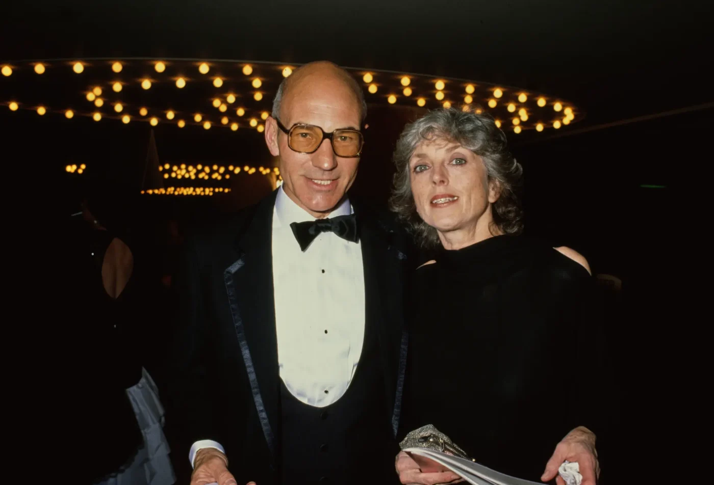 British actor Patrick Stewart in a tuxedo and bow tie, with his wife Sheila Falconer in a black outfit, at the Golden Globe Awards.
