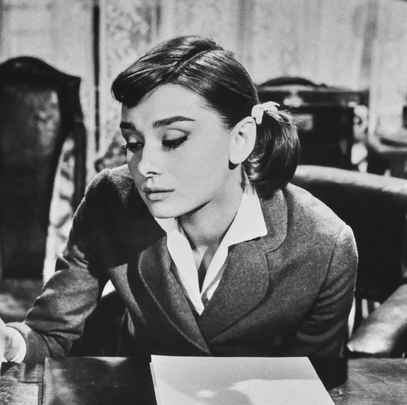 British actress Audrey Hepburn wearing her hair in pigtails with ribbons in each and side bangs