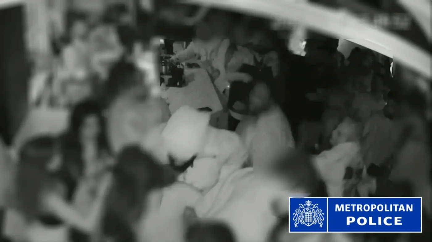CCTV footage shows a crowded room with the Metropolitan Police logo in the bottom right corner.