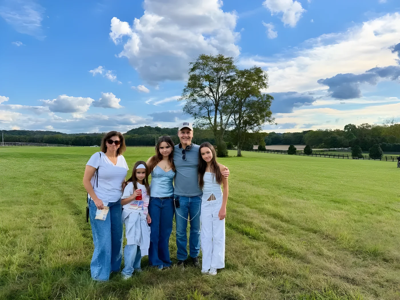 Chad Lowe standing in a field with his wife Kim with their three daughters