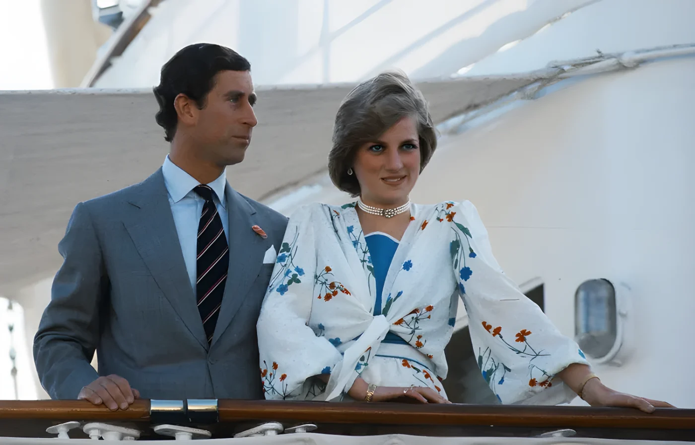 Charles and Diana standing on a deck facing different directions