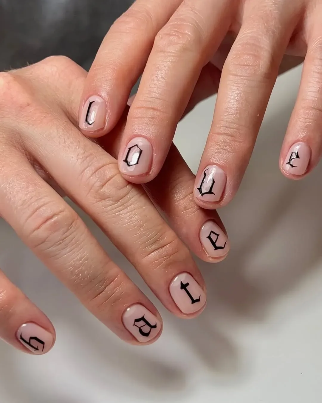 Close up of hands with a manicure that says love and hate