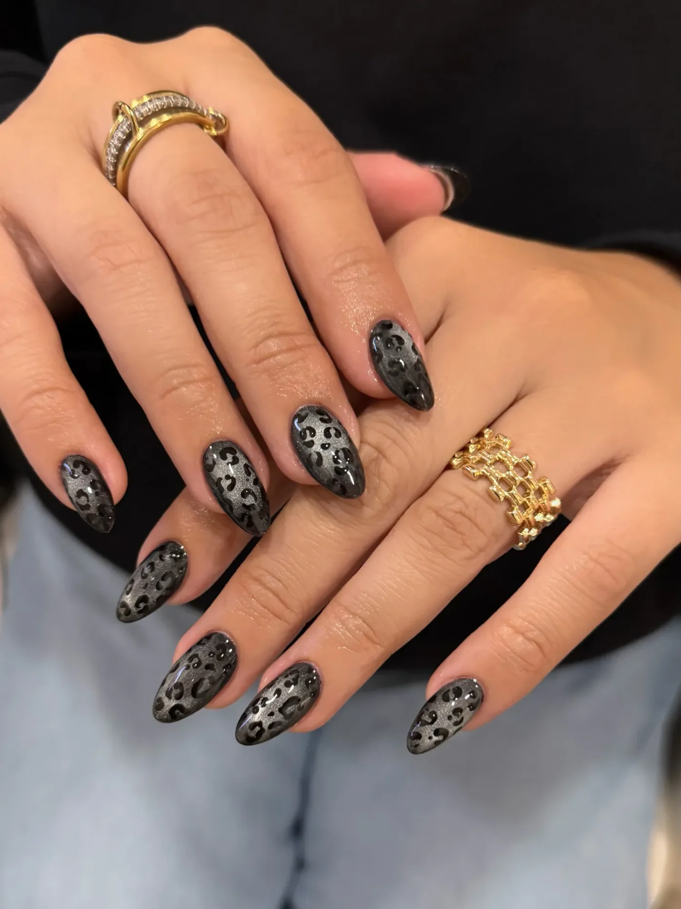 Closeup of hands with leopard print nail art and rings