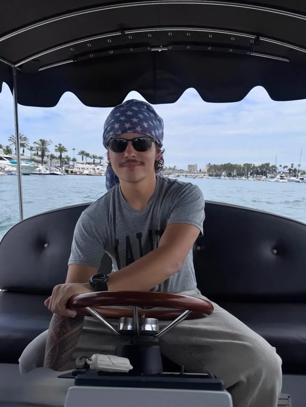 Collin Gosselin sits at the helm of a boat, wearing a star-spangled bandana and sunglasses.