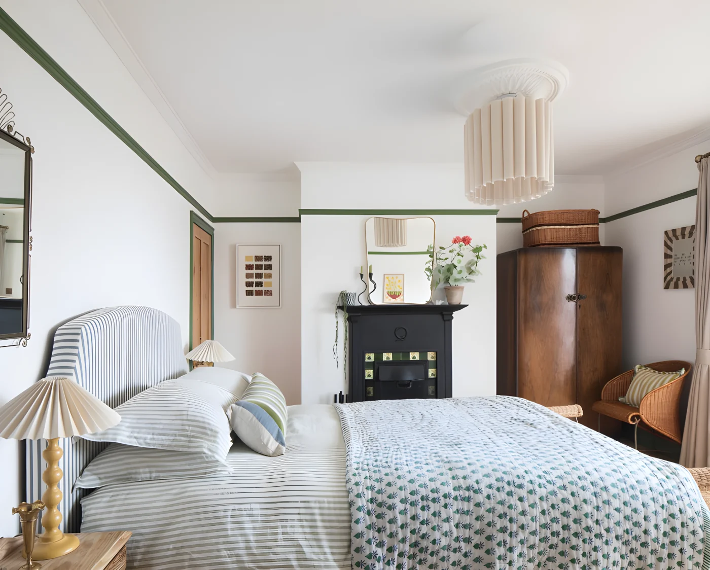 cozy bedroom with striped bedding, patterned quilt, wicker furniture, and a vintage fireplace.