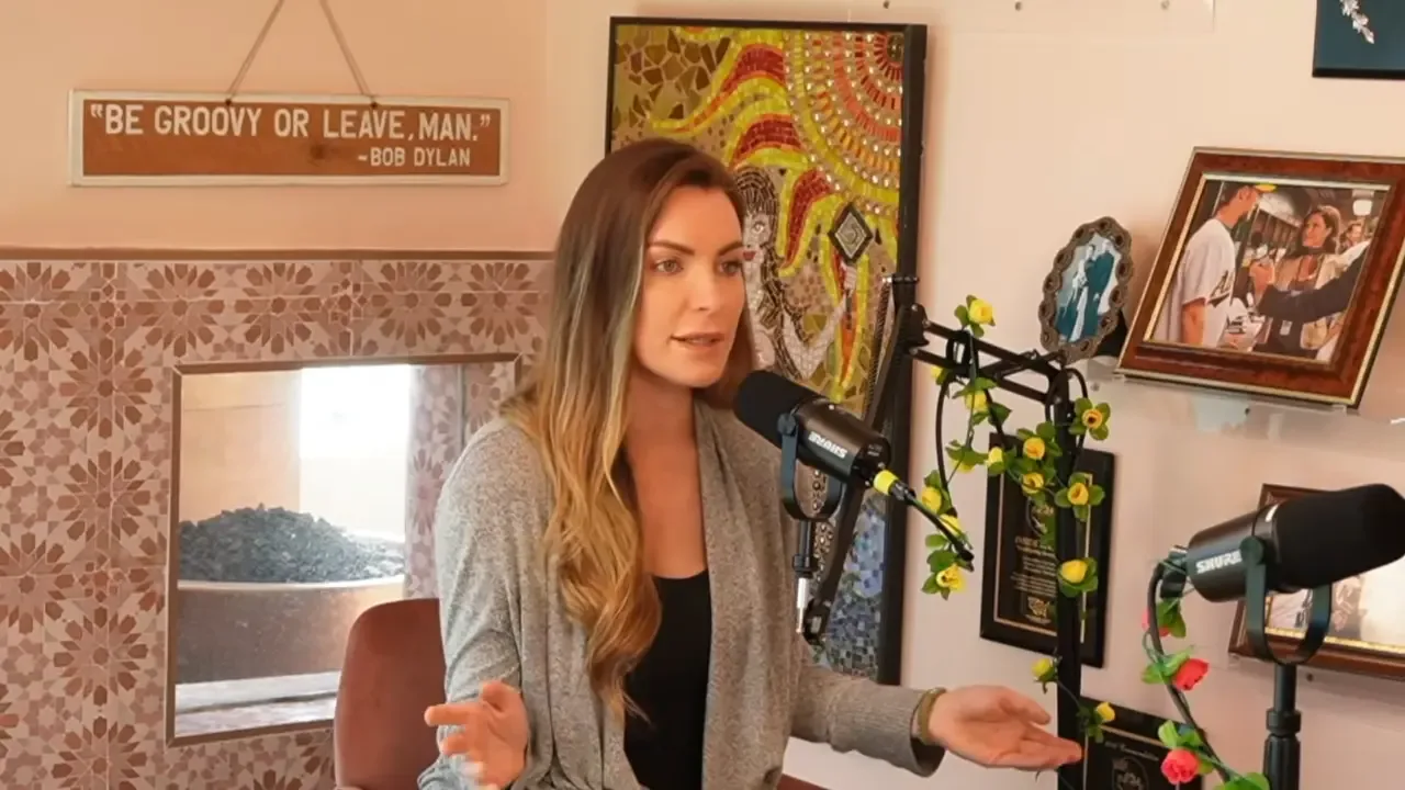 Crystal Hefner sitting in front of a microphone and speaking during an interview.