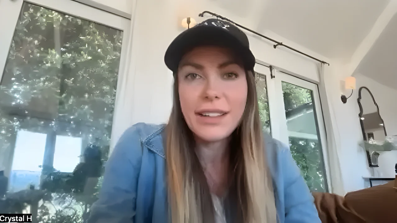 Crystal Hefner wearing a black cap and denim jacket indoors.