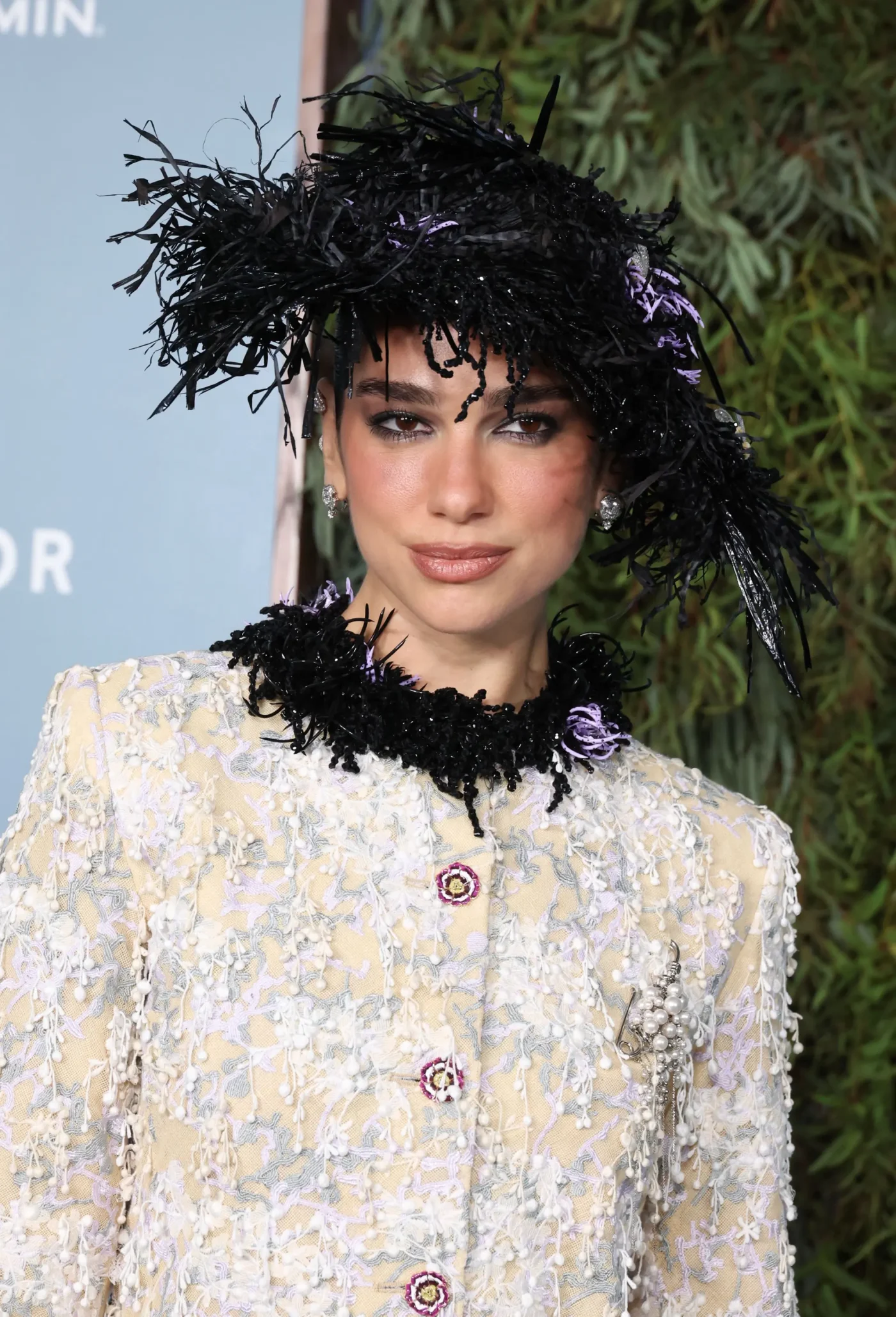 Dua Lipa wearing a feathered hat and textured jacket at the WSJ. Magazine Innovator Awards.