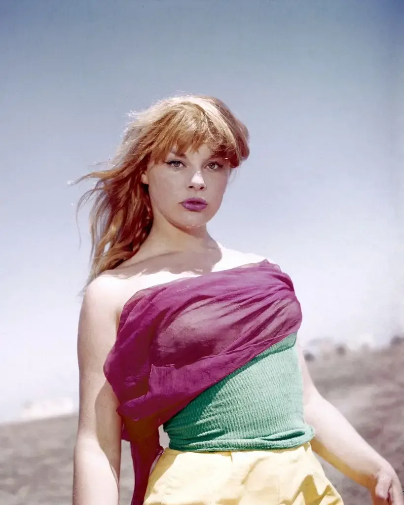 Elke Sommer, German actress, wearing a pink, green and yellow outfit, with the sea in the background, circa 1965.