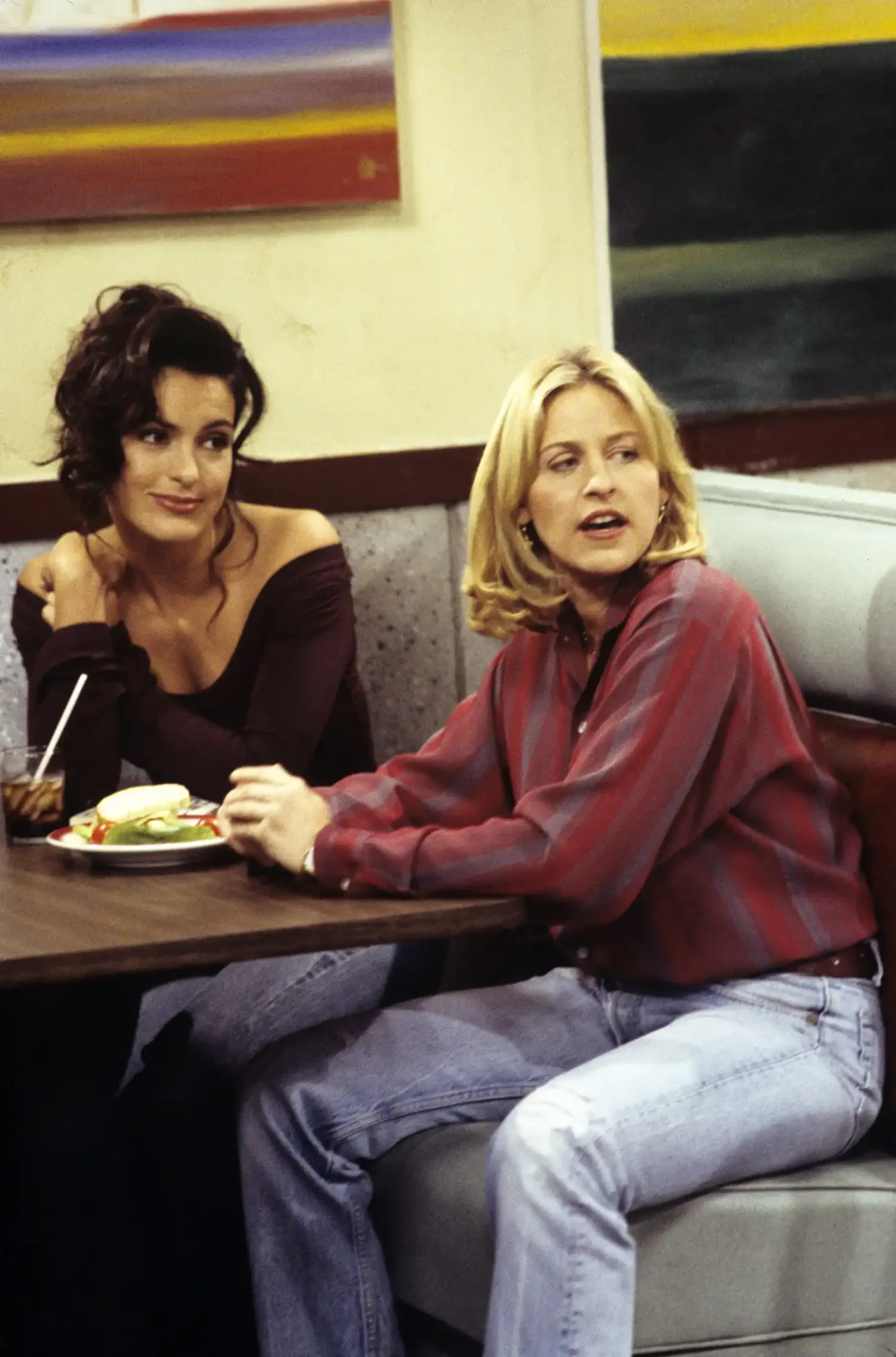 Ellen DeGeneres and Mariska Hargitay seated in a booth engaged in conversation