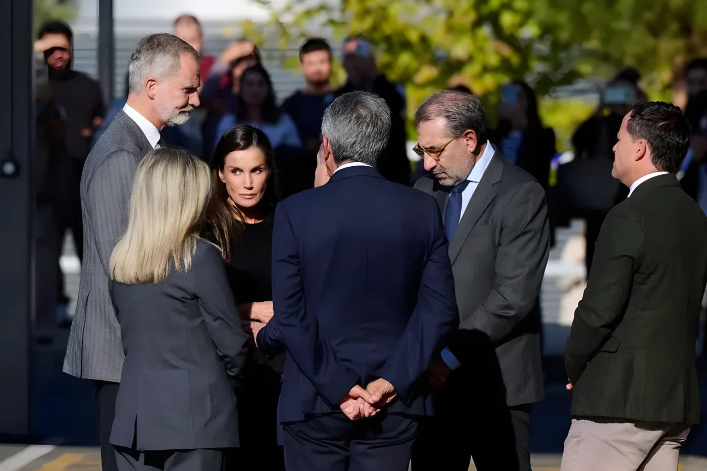 Felipe VI of Spain stands with a group of formally dressed individuals, engaged in conversation.