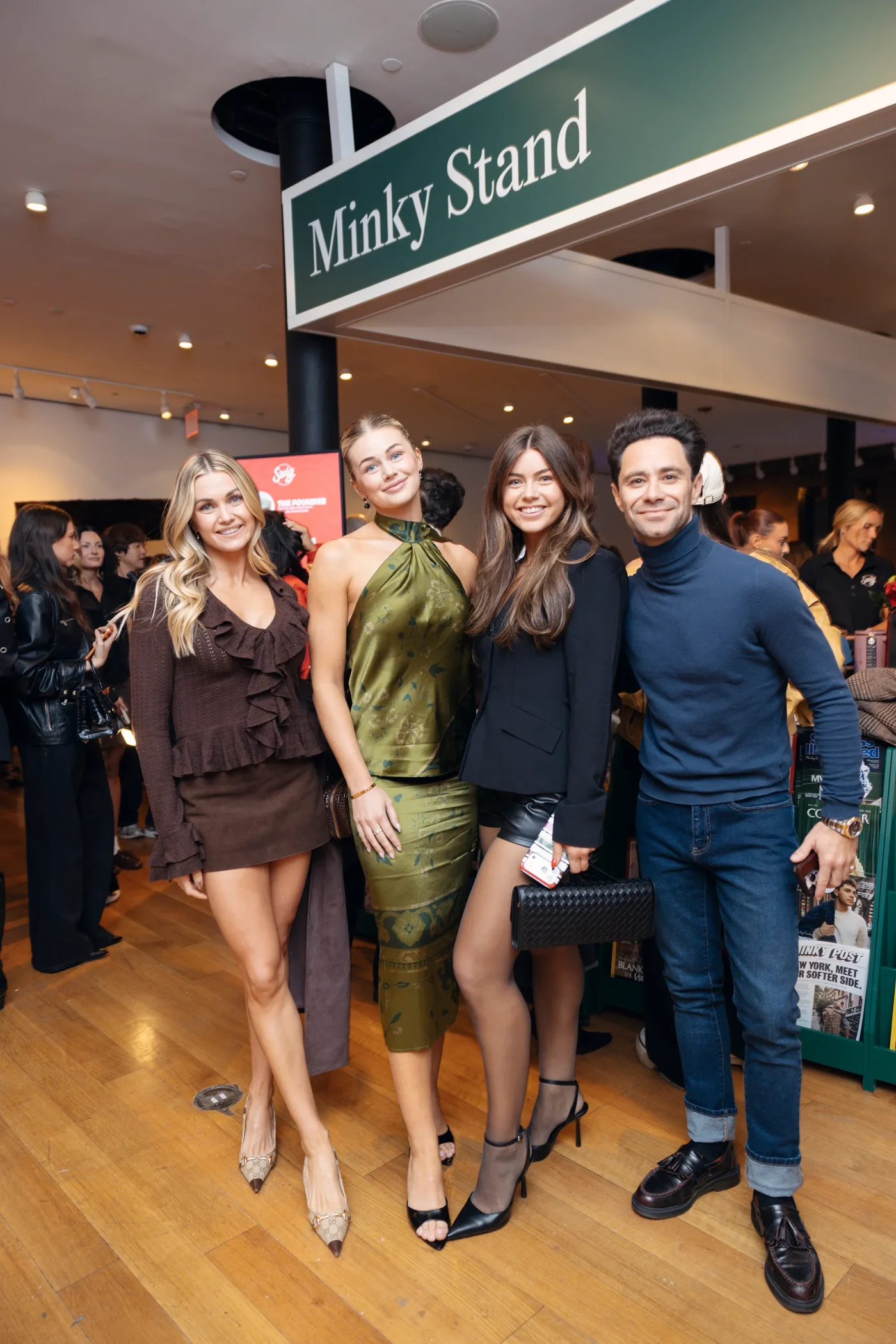 Four people standing and smiling at the Minky Stand.
