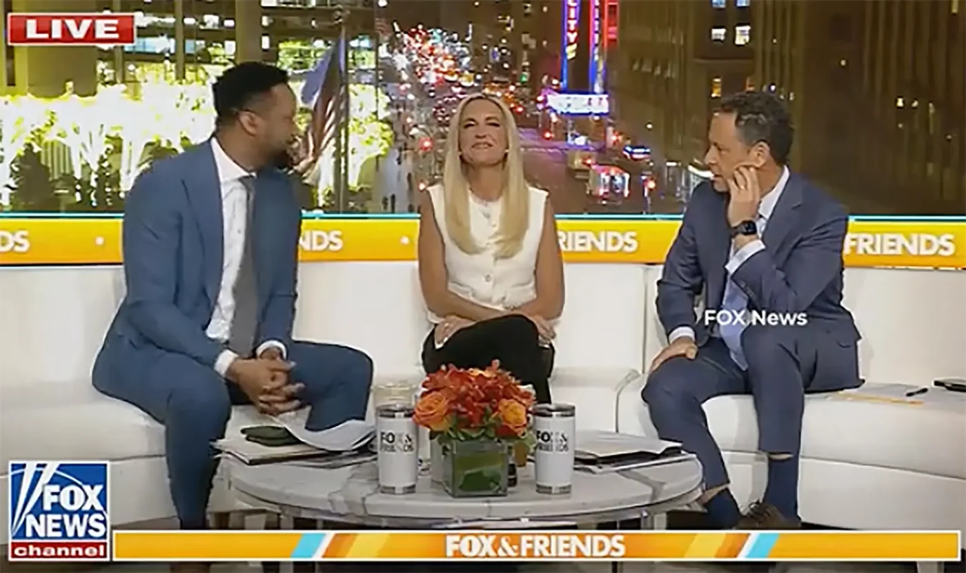 Fox & Friends hosts sit on a couch on the set.