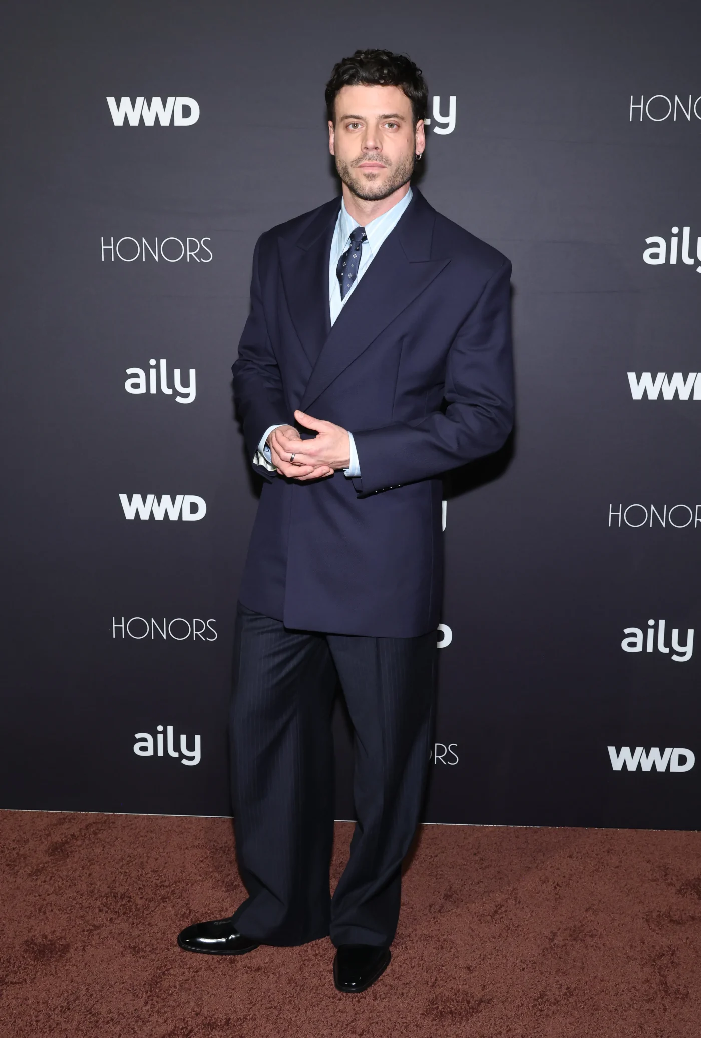 François Arnaud attends the WWD Honors in a navy double-breasted suit.